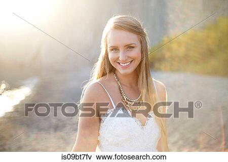 Stock Photo - Bride in wedding dress on beach at sunset. Fotosearch