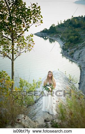 Bride with bouquet on clifftop by coast, Scarborough Bluffs, Toronto, Canada View Large Photo Image Stock Photo - Bride with bouquet on clifftop by coast, Scarborough Bluffs, Toronto, Canada. Fotosearch