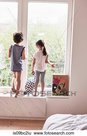 Brother and sister looking out of window, rear view View Large Photo Image Stock Photograph - Brother and sister looking out of window, rear view. Fotosearch