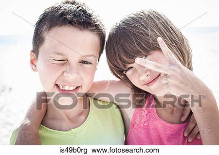 Stock Image - Brother with sister making peace sign. Fotosearch