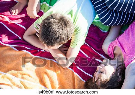 Stock Image - Brothers and sister on picnic blanket. Fotosearch