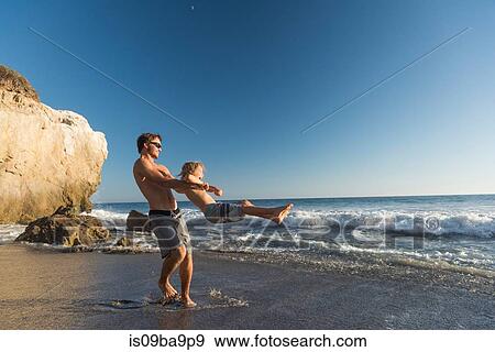 Stock Photo - Brothers playing on El Matador Beach, Malibu, USA. Fotosearch