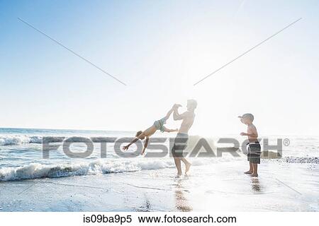 Stock Photography - Brothers playing on El Matador Beach, Malibu, USA. Fotosearch