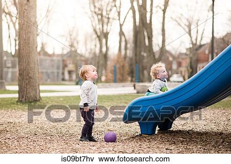 Brothers playing on slide View Large Photo Image Stock Photo - Brothers playing on slide. Fotosearch
