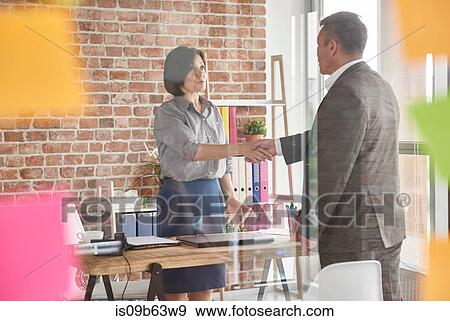 Stock Photo - Business people in office shaking hands. Fotosearch