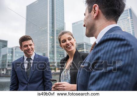 Businessman and businesswoman in discussion outdoors, Canary Wharf, London, UK View Large Photo Image Stock Image - Businessman and businesswoman in discussion outdoors, Canary Wharf, London, UK. Fotosearch
