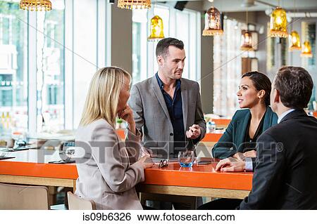 Stock Photograph - Businessman and businesswoman in discussion in cafe. Fotosearch
