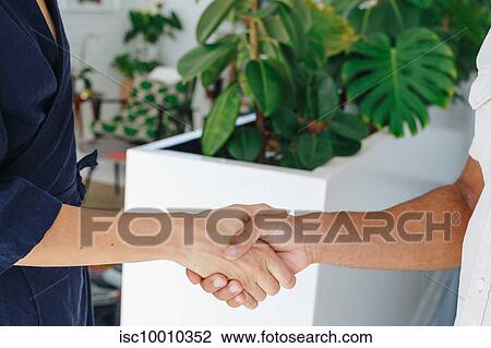 Businessman and businesswoman shaking hands in office View Large Photo Image Stock Image - Businessman and businesswoman shaking hands in office. Fotosearch