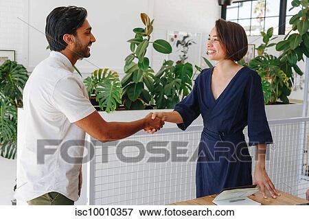 Businessman and businesswoman shaking hands in office View Large Photo Image Stock Photo - Businessman and businesswoman shaking hands in office. Fotosearch