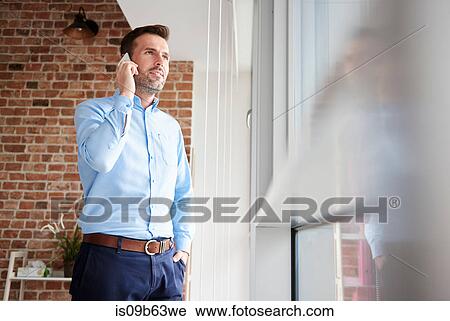 Stock Image - Businessman in office making telephone. Fotosearch