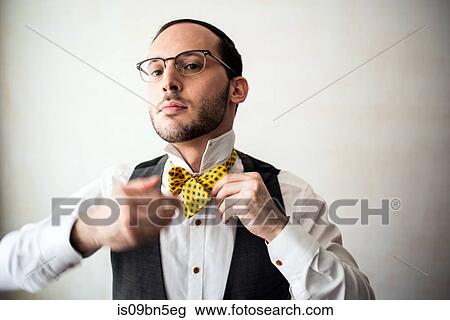 Businessman putting on bow tie View Large Photo Image Stock Image - Businessman putting on bow tie. Fotosearch