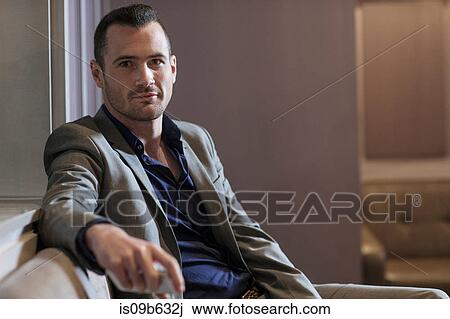 Stock Image - Businessman taking break on couch. Fotosearch