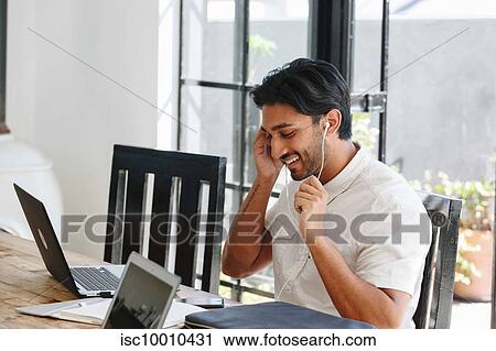 Stock Image - Businessman talking on cellular phone in office. Fotosearch