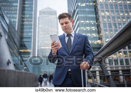 Businessman using mobile phone, Canary Wharf, London, UK View Large Photo Image Picture - Businessman using mobile phone, Canary Wharf, London, UK. Fotosearch