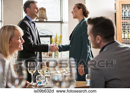 Stock Image - Businessmen and businesswomen at lunch in restaurant. Fotosearch