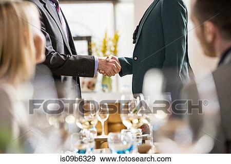 Stock Photo - Businessmen and businesswomen at lunch in restaurant. Fotosearch