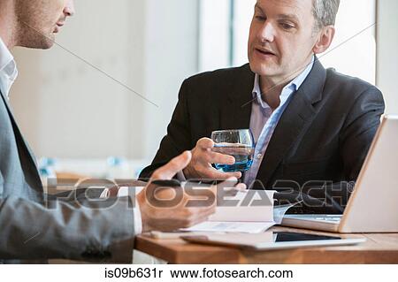 Stock Photography - Businessmen working and making notes of discussion. Fotosearch
