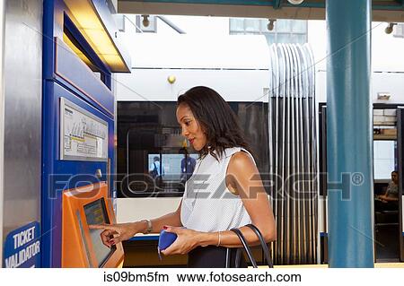 Businesswoman buying train ticket at machine View Large Photo Image Picture - Businesswoman buying train ticket at machine. Fotosearch