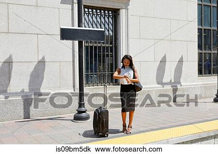 Businesswoman checking time on kerb View Large Photo Image Stock Image - Businesswoman checking time on kerb. Fotosearch