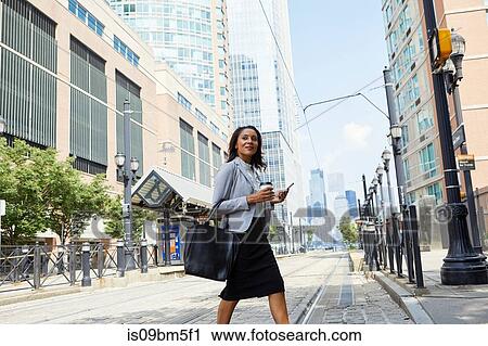 Businesswoman crossing light rail tracks View Large Photo Image Stock Image - Businesswoman crossing light rail tracks. Fotosearch