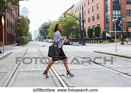 Businesswoman crossing light rail tracks View Large Photo Image Stock Photo - Businesswoman crossing light rail tracks. Fotosearch