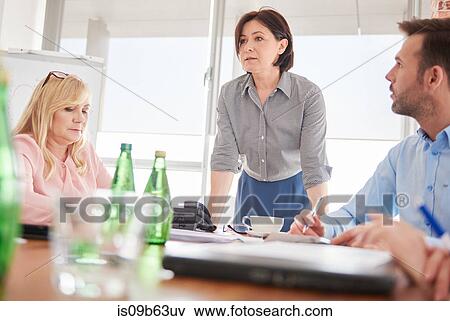 Stock Photo - Businesswoman leading business meeting. Fotosearch