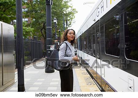 Stock Photo - Businesswoman on platform by train. Fotosearch