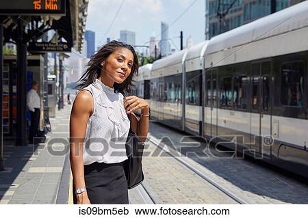 Stock Image - Businesswoman on train station platform. Fotosearch