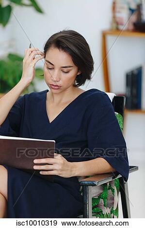 Businesswoman preparing paperwork in office View Large Photo Image Stock Photo - Businesswoman preparing paperwork in office. Fotosearch