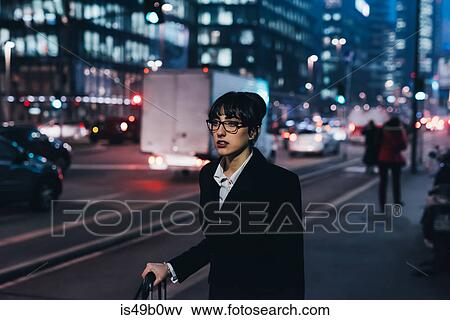 Stock Photo - Businesswoman pulling trolley luggage, Milan, Italy. Fotosearch