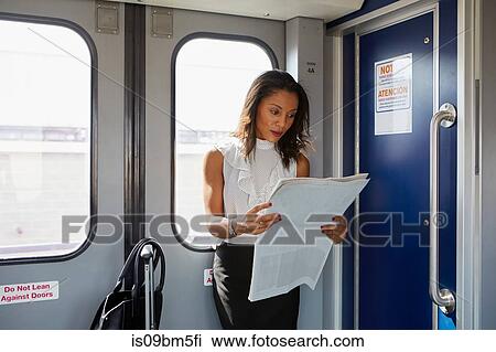 Businesswoman reading newspapers on train View Large Photo Image Stock Image - Businesswoman reading newspapers on train. Fotosearch
