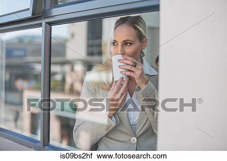 Businesswoman taking coffee break in office View Large Photo Image Stock Image - Businesswoman taking coffee break in office. Fotosearch