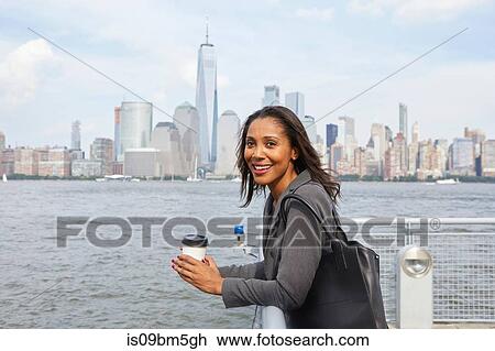 Businesswoman taking coffee break, New York City skyline in background View Large Photo Image Stock Image - Businesswoman taking coffee break, New York City skyline in background. Fotosearch