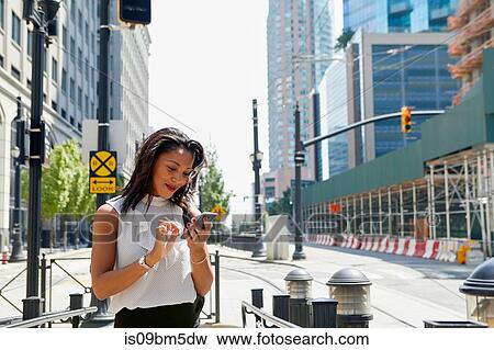 Businesswoman using cellphone by barriers View Large Photo Image Stock Photo - Businesswoman using cellphone by barriers. Fotosearch