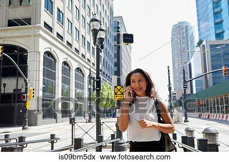Businesswoman using cellphone by barriers View Large Photo Image Stock Photo - Businesswoman using cellphone by barriers. Fotosearch
