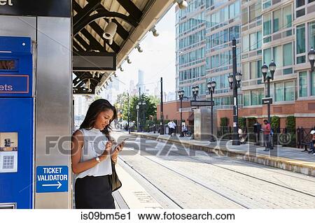 Businesswoman using cellphone by ticket machine View Large Photo Image Stock Image - Businesswoman using cellphone by ticket machine. Fotosearch