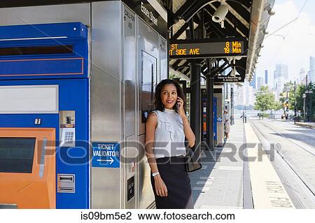 Businesswoman using cellphone by ticket machine View Large Photo Image Stock Image - Businesswoman using cellphone by ticket machine. Fotosearch
