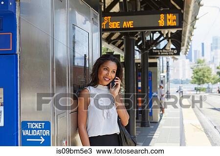Businesswoman using cellphone by ticket machine View Large Photo Image Stock Image - Businesswoman using cellphone by ticket machine. Fotosearch