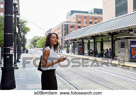 Businesswoman using cellphone in light rail station View Large Photo Image Picture - Businesswoman using cellphone in light rail station. Fotosearch