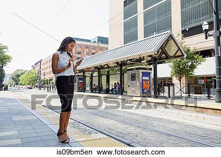 Businesswoman using cellphone in light rail station View Large Photo Image Picture - Businesswoman using cellphone in light rail station. Fotosearch