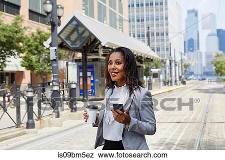 Businesswoman using cellphone in light rail station View Large Photo Image Stock Photo - Businesswoman using cellphone in light rail station. Fotosearch