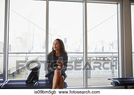 Businesswoman using cellphone inside ferry terminal View Large Photo Image Stock Image - Businesswoman using cellphone inside ferry terminal. Fotosearch