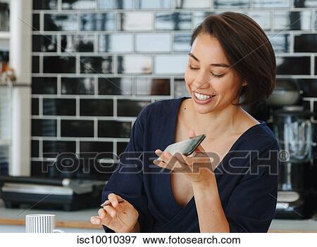 Businesswoman using cellular phone in pantry View Large Photo Image Stock Photo - Businesswoman using cellular phone in pantry. Fotosearch