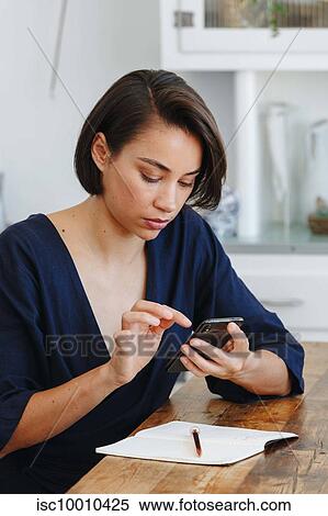 Businesswoman using cellular phone in office View Large Photo Image Stock Photography - Businesswoman using cellular phone in office. Fotosearch