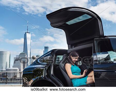 Businesswoman using digital tablet in car, Jersey City, New Jersey, USA View Large Photo Image Stock Photograph - Businesswoman using digital tablet in car, Jersey City, New Jersey, USA. Fotosearch