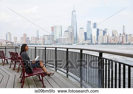 Businesswoman using digital tablet, New York City skyline in background View Large Photo Image Picture - Businesswoman using digital tablet, New York City skyline in background. Fotosearch