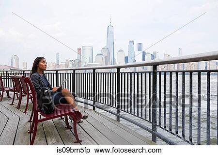 Businesswoman using digital tablet, New York City skyline in background View Large Photo Image Stock Photography - Businesswoman using digital tablet, New York City skyline in background. Fotosearch