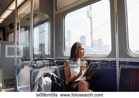 Businesswoman using digital tablet on train View Large Photo Image Stock Image - Businesswoman using digital tablet on train. Fotosearch