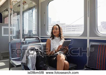 Businesswoman using digital tablet on train View Large Photo Image Stock Photo - Businesswoman using digital tablet on train. Fotosearch