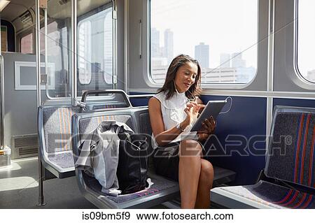 Businesswoman using digital tablet on train View Large Photo Image Stock Photo - Businesswoman using digital tablet on train. Fotosearch